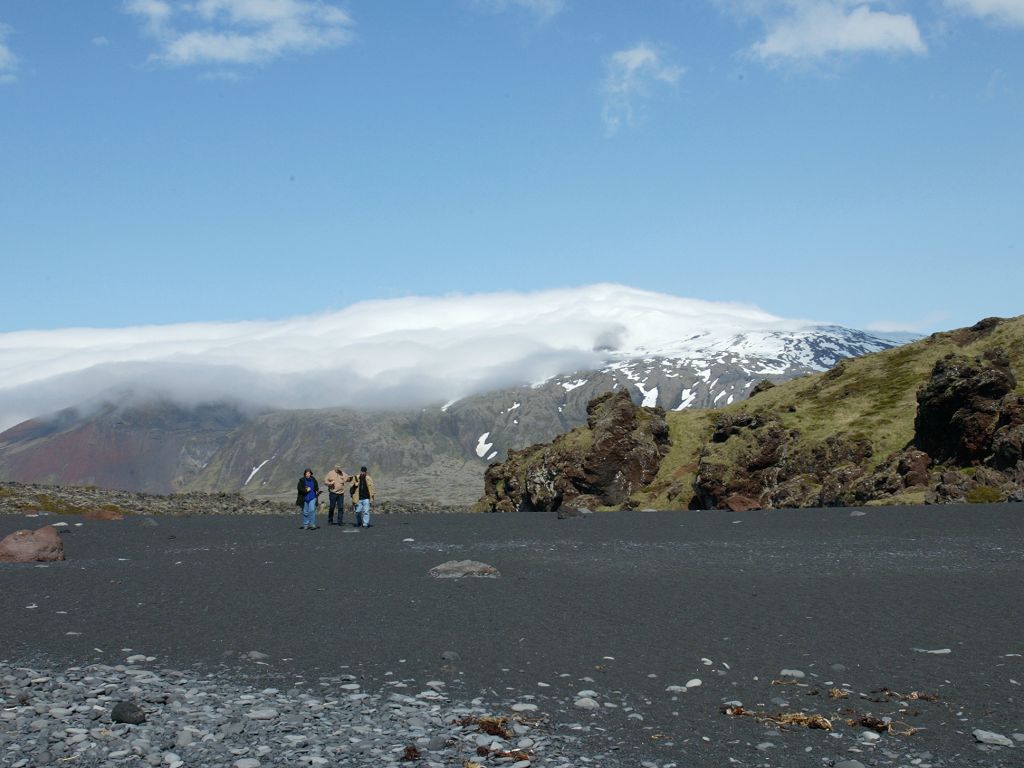 With Snæfell looming in the background, the rest of our little group walks down a large black sand beach.  Click for next photo.