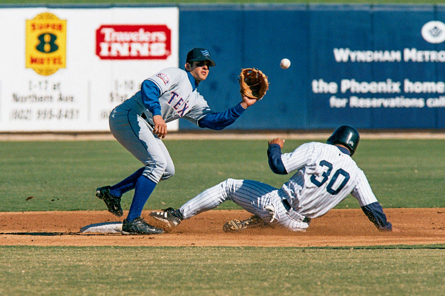 Phoenix Larry Barnes (Angels) slides in as Grand Canyon shortstop Mike Young (Rangers) defends, Arizona Fall League, 2000.  Click for next photo.