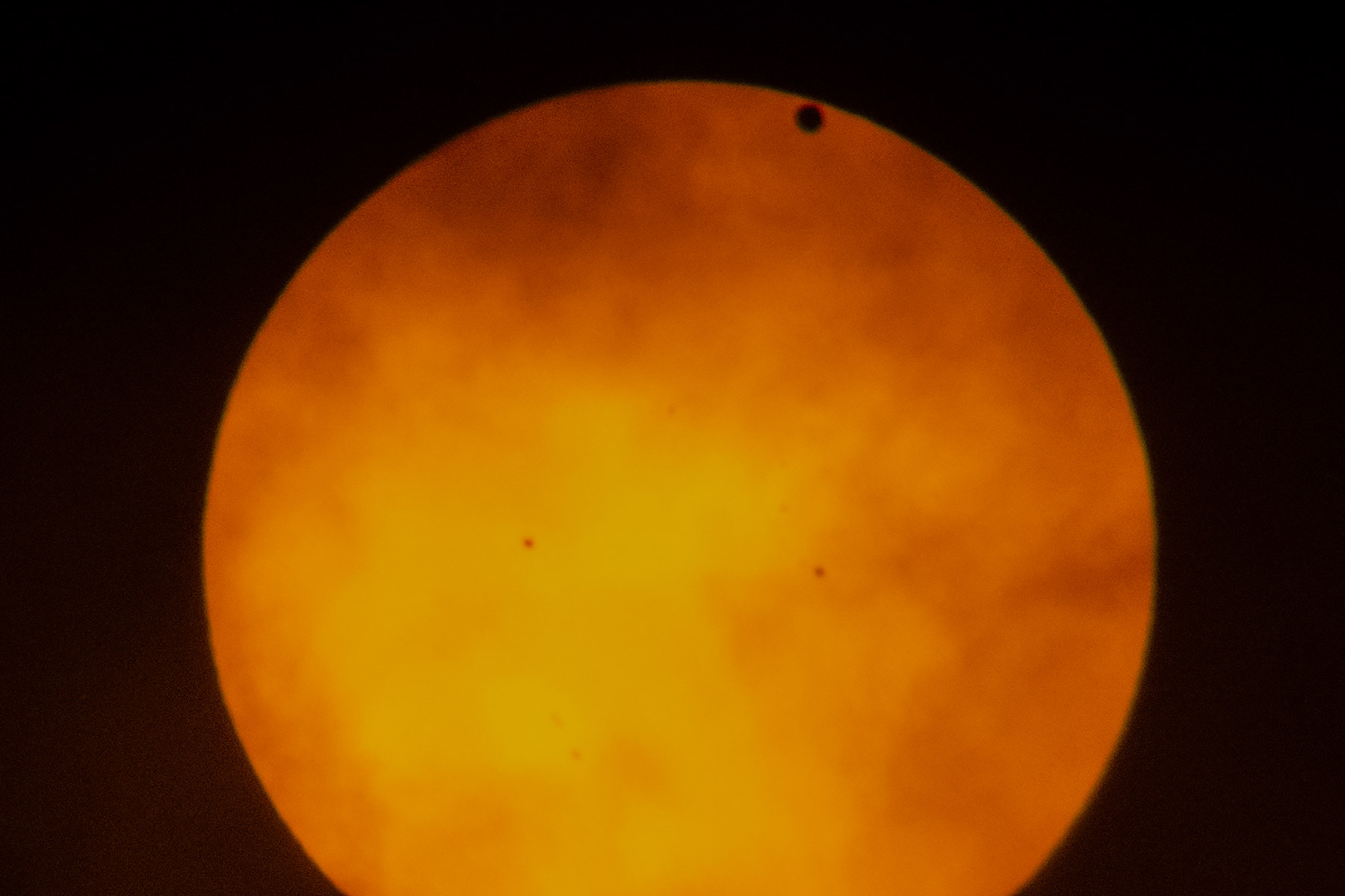 Transit of Venus, taken in New York City, June 5, 2012.  I was on extended assignment and didnt have my big scopes or camera, so I took this with a small handheld camera through my binoculars, which were covered by a solar filter.  I have some somewhat better photos from the 2004 transit.  Transits come in pairs separated by long gaps, so the next transit will not occur until 2117.  Click for next photo.
