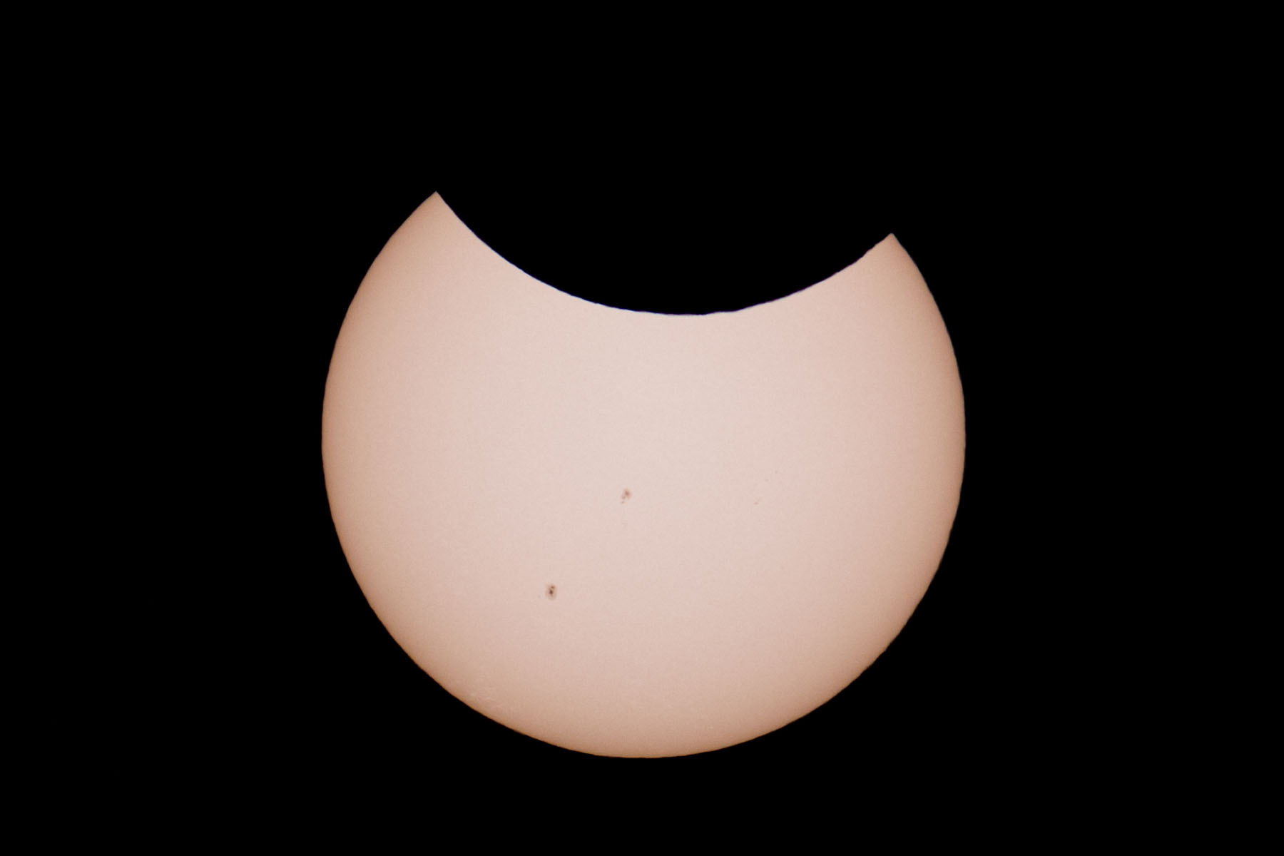 Annular solar eclipse, 58 minutes before peak.  Glass solar filter on Televue 85 telescope, Canon 6D Mark II camera on T-mount, 600mm F7 equivalent.  Click for next photo.